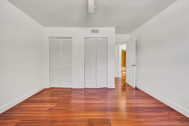 a view of empty room with wooden floor