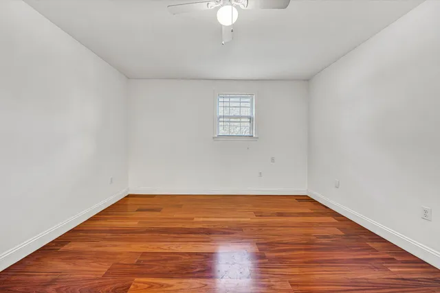 a view of a room with wooden floor and white walls