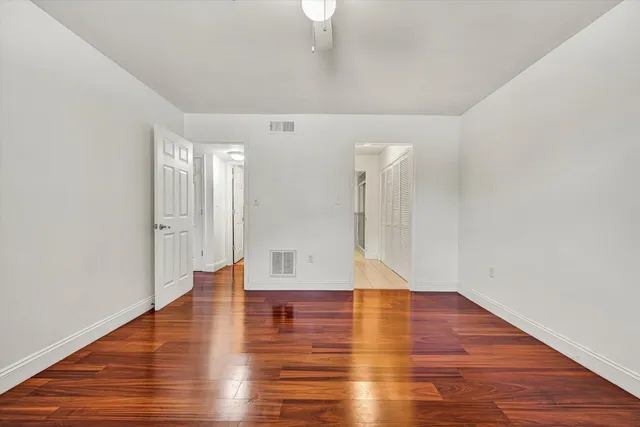 a view of empty room with wooden floor