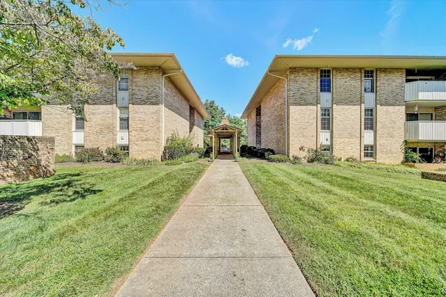 a view of a house with a big yard and large trees