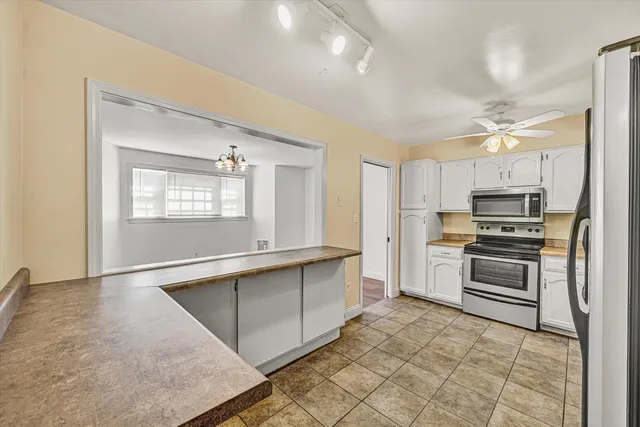 a kitchen with stainless steel appliances a stove a sink cabinets and a refrigerator
