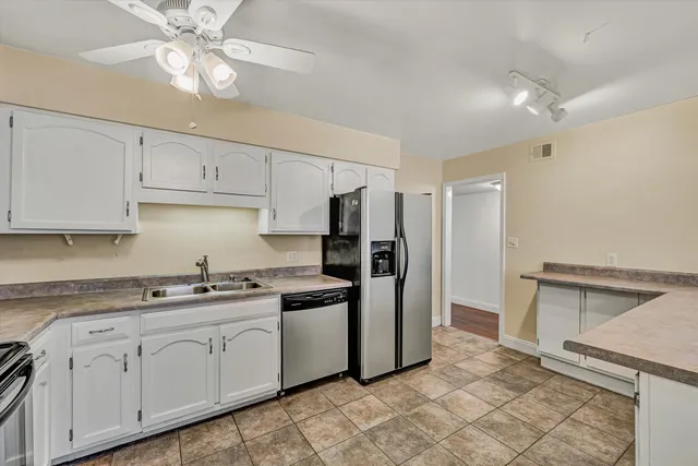 a kitchen with stainless steel appliances granite countertop a sink a stove a refrigerator and cabinets