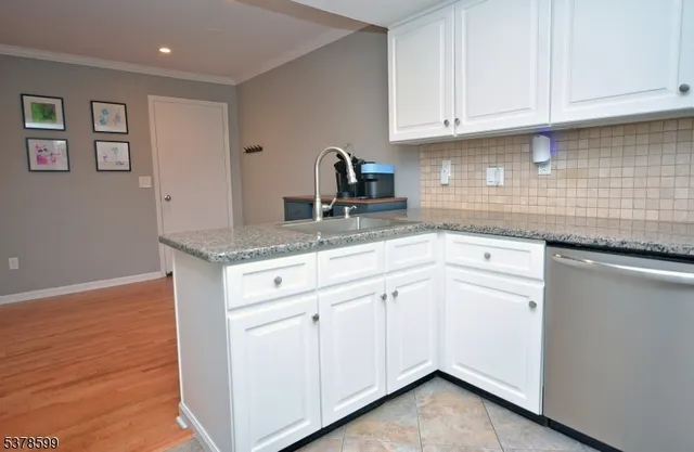 a kitchen with granite countertop white cabinets and sink