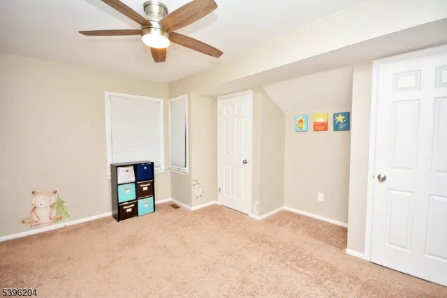 a view of a bedroom with a bed and a ceiling fan