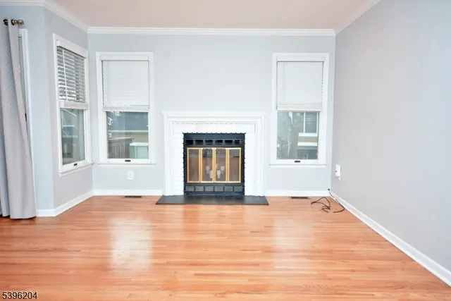 a view of empty room with wooden floor and fireplace