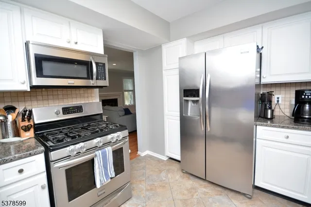 a kitchen with stainless steel appliances granite countertop a stove a refrigerator and a microwave
