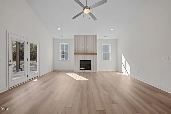 a view of empty room with wooden floor and fireplace