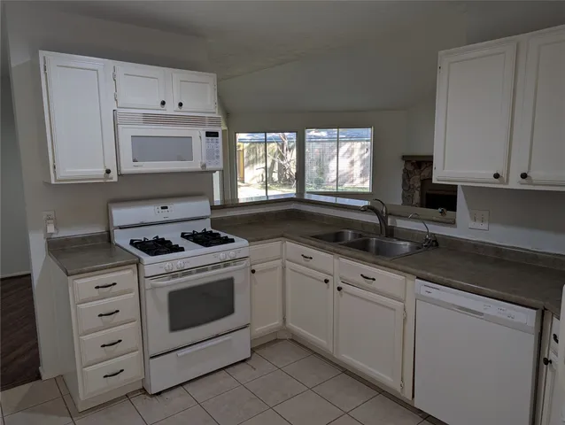 a kitchen with cabinets stainless steel appliances a sink and a stove