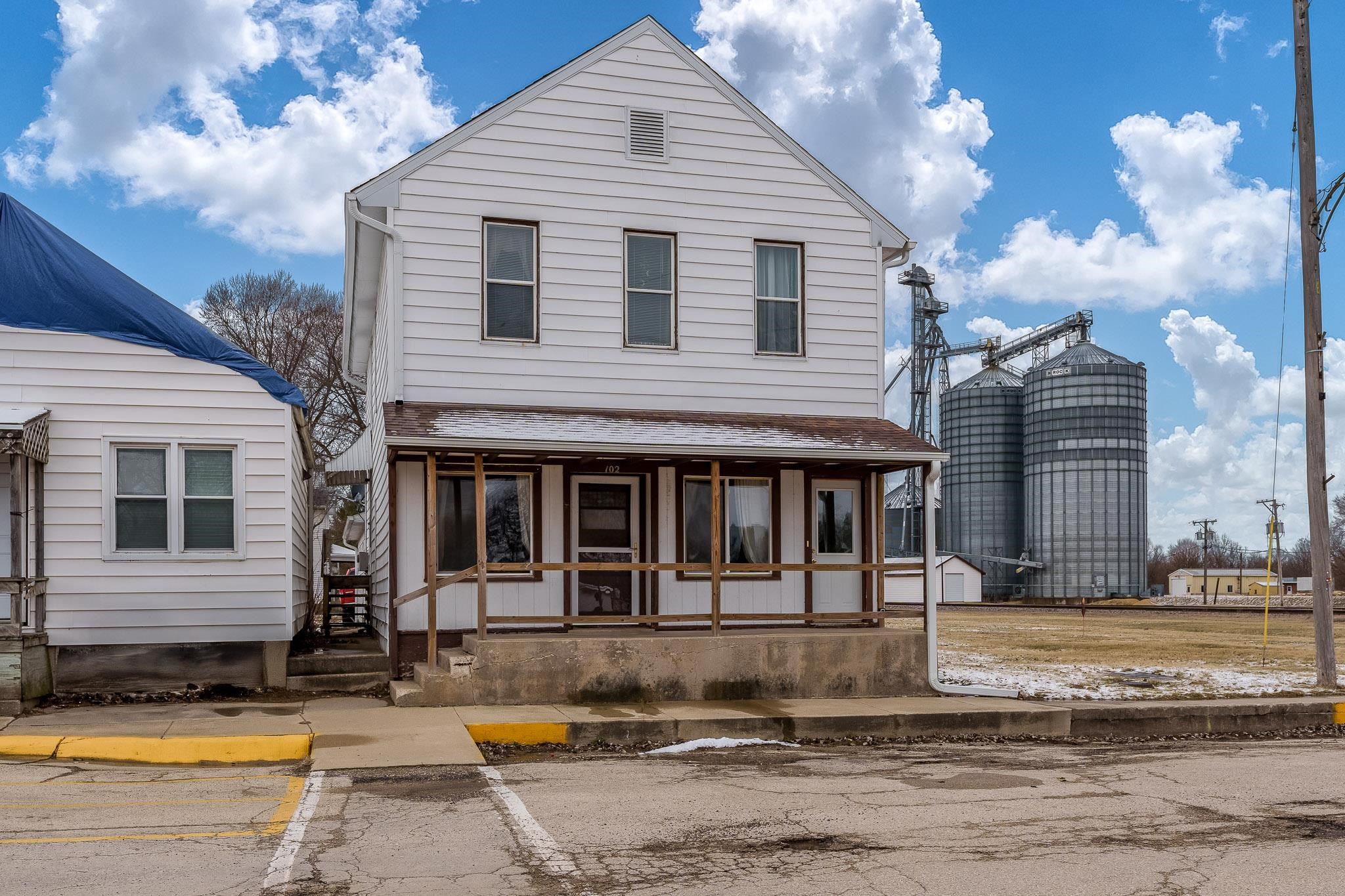 a view of a white house with large windows and a small yard