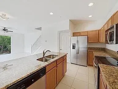 a kitchen with granite countertop a sink stove and refrigerator