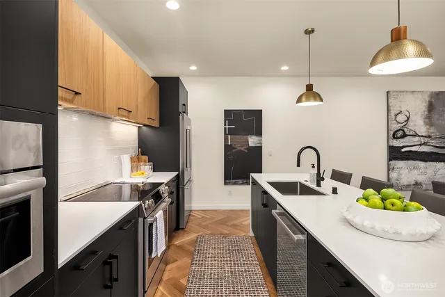 a kitchen with stainless steel appliances granite countertop a sink a stove and a refrigerator