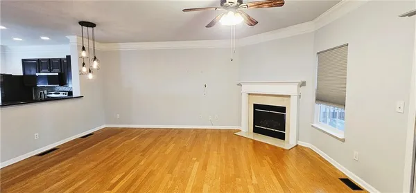 a view of empty room with wooden floor and fireplace