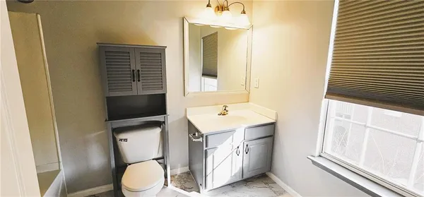 a bathroom with a sink a toilet a mirror and shower