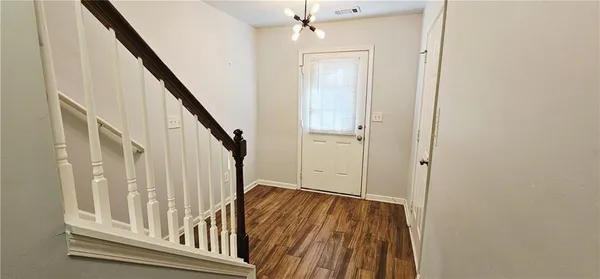a view of staircase with wooden floor and white walls
