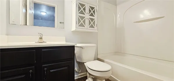 a bathroom with a sink vanity granite toilet and a bathtub