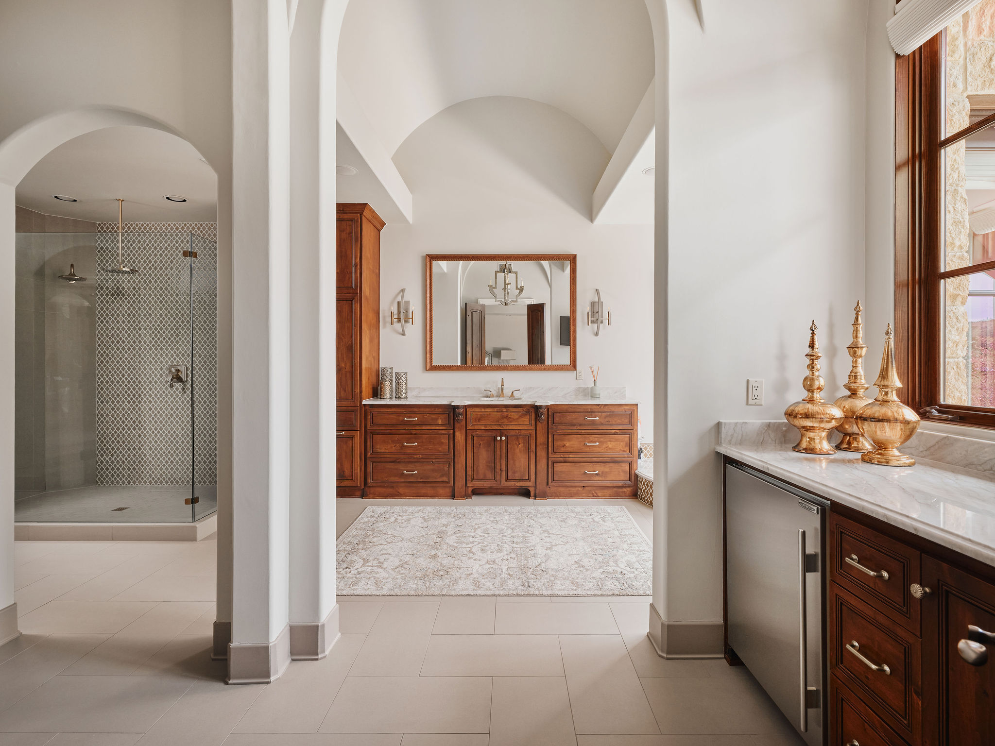 433 Brandon Way Austin, TX 78733 - Photo 15 of 40 Arched doorways and vaulted ceilings define this opulent primary bath with elegant wood vanities.