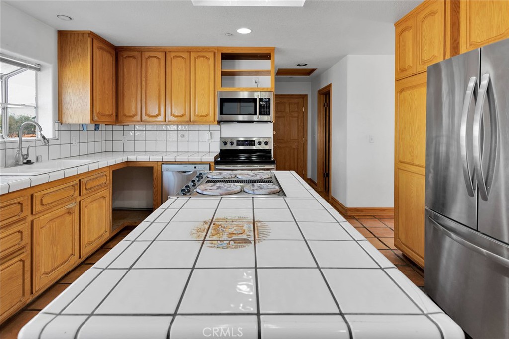 8381 White Road Phelan, CA 92371 - Photo 14 of 59 a kitchen with stainless steel appliances granite countertop a refrigerator and a stove top oven