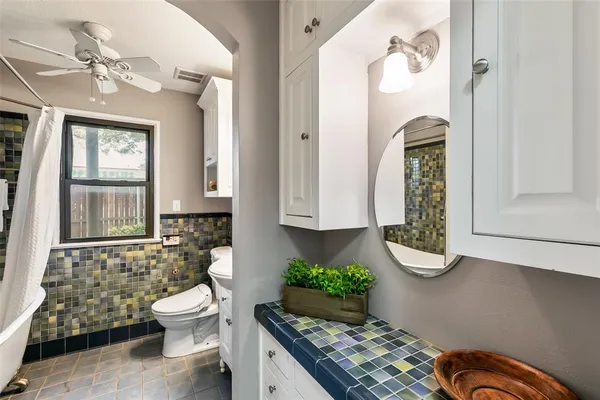 a bathroom with a granite countertop toilet sink and mirror