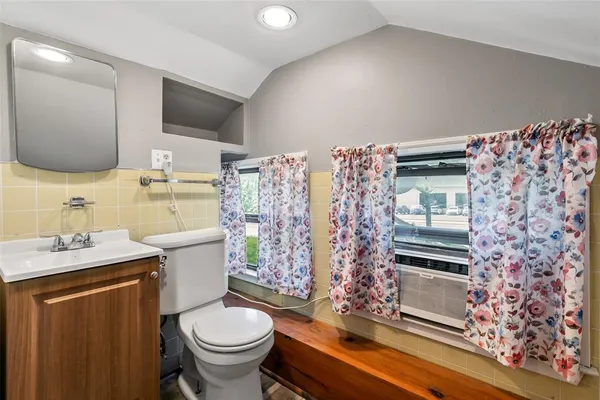 a bathroom with a granite countertop toilet sink and mirror