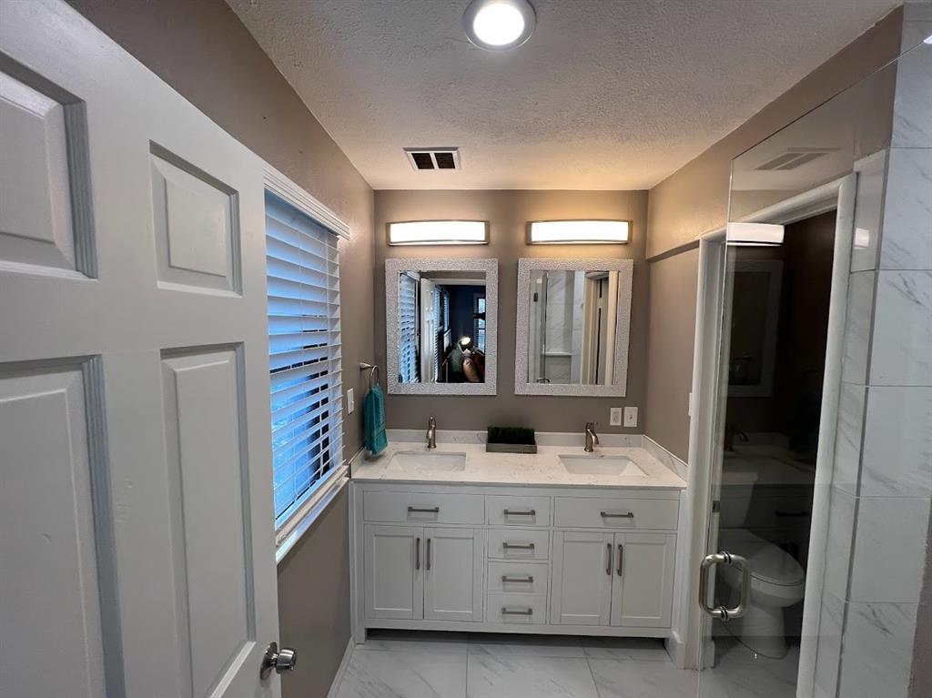 4206 Somerville Avenue Dallas, TX 75206 - Photo 21 of 26 a bathroom with a double vanity sink and mirror