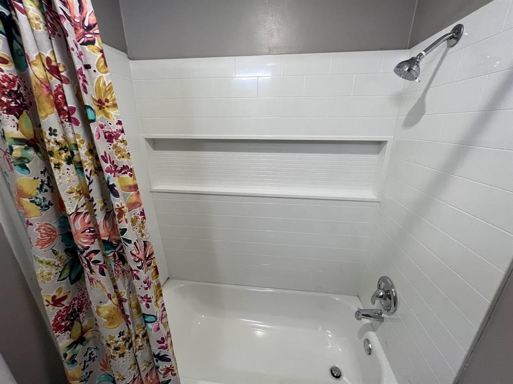 4206 Somerville Avenue Dallas, TX 75206 - Photo 23 of 26 a bathroom with a bathtub and shower curtain
