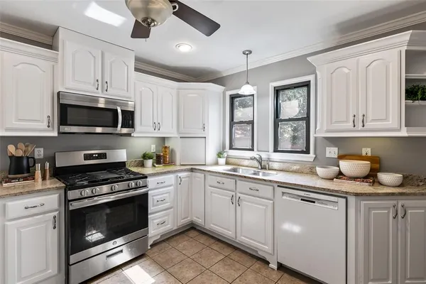 a kitchen with granite countertop a stove sink and microwave