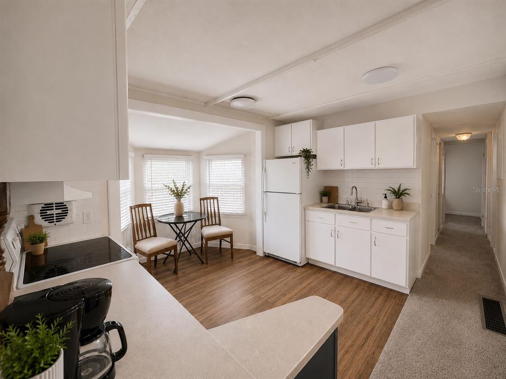 3074 Larkin Road Mims, FL 32754 - Photo 5 of 15 a kitchen with white cabinets and stainless steel appliances