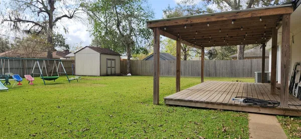 a view of backyard with small cabin and wooden fence