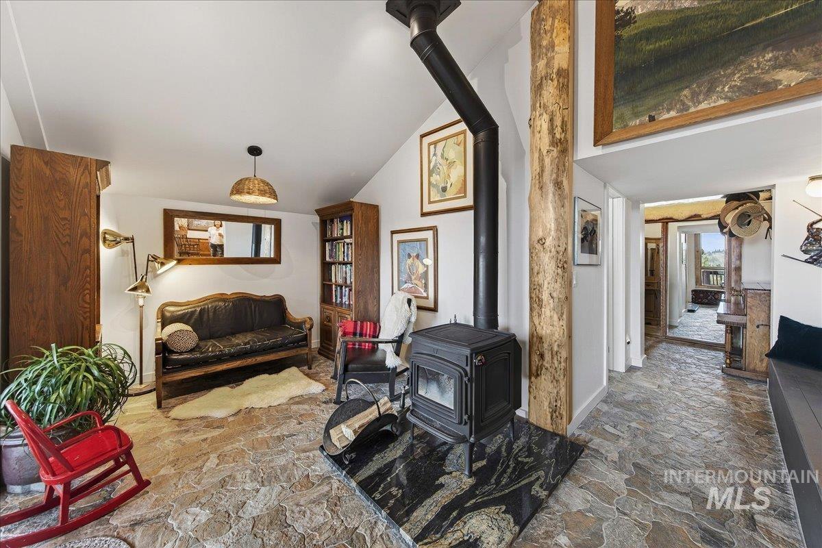 239 Tollgate Road Boise, ID 83716 - Photo 16 of 50 Living area with stone looking pavers, a wood stove, and vaulted ceiling