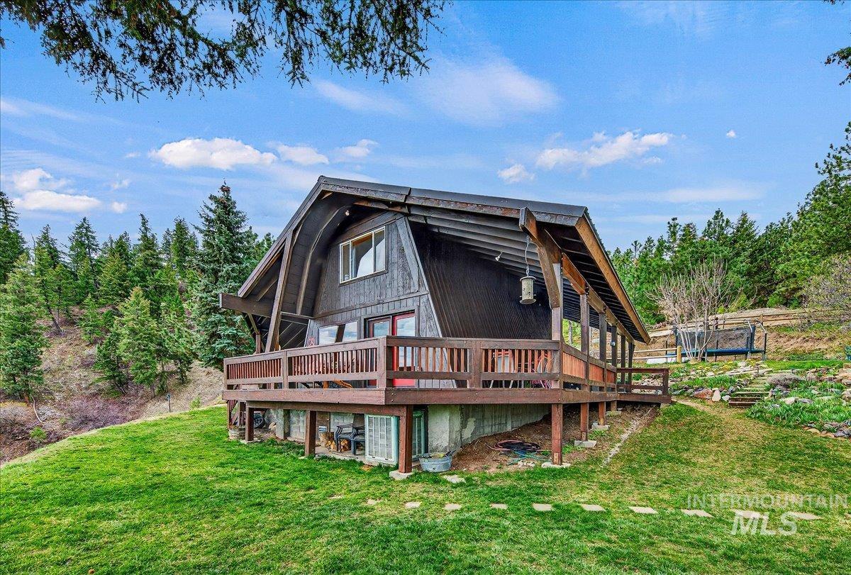 239 Tollgate Road Boise, ID 83716 - Photo 22 of 50 Back of property featuring a deck, a yard, and a trampoline