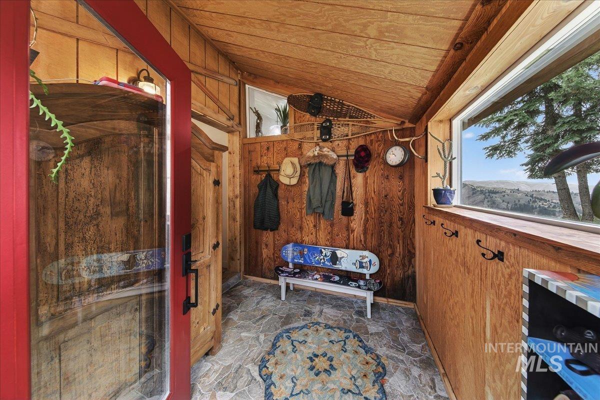 239 Tollgate Road Boise, ID 83716 - Photo 31 of 50 Mudroom featuring wooden walls, stone flooring, and a vaulted wooden ceiling