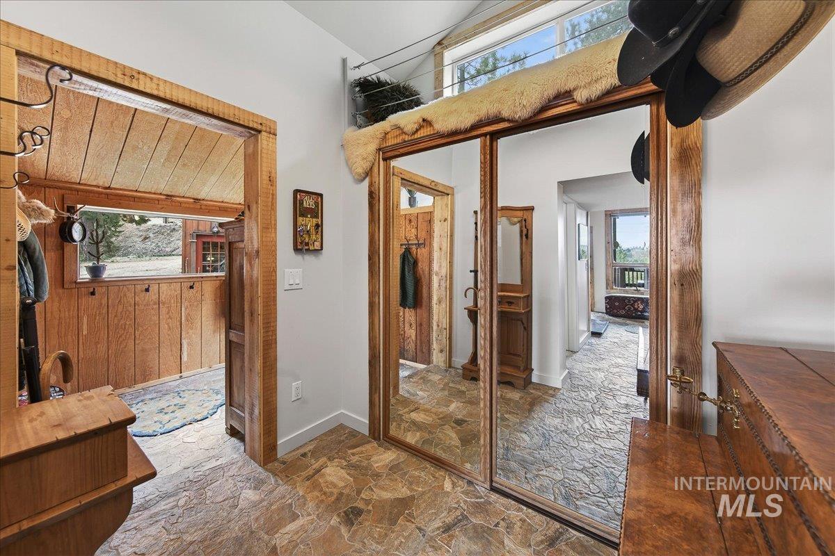 239 Tollgate Road Boise, ID 83716 - Photo 32 of 50 Bathroom with stone flooring, healthy amount of natural light, wood walls, a high ceiling, and vanity