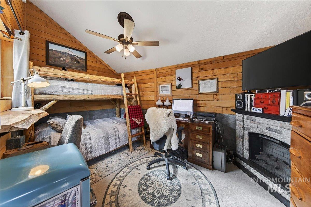 239 Tollgate Road Boise, ID 83716 - Photo 35 of 50 Bunkhouse with wood walls, a fireplace, light carpet, vaulted ceiling, and a ceiling fan