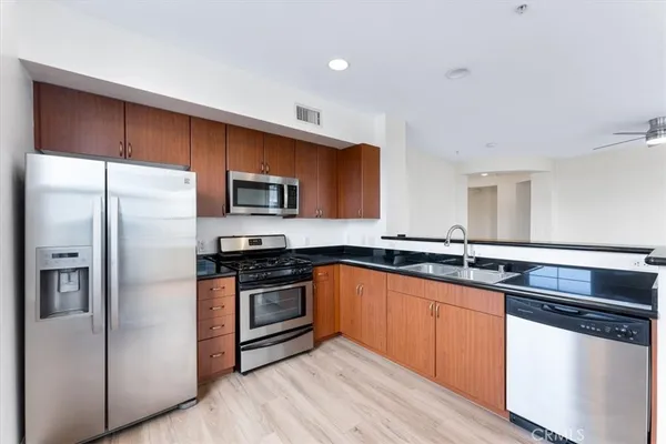 a kitchen with stainless steel appliances granite countertop a refrigerator and a stove
