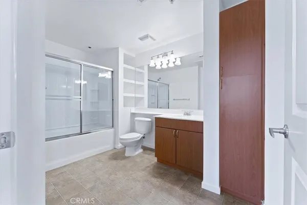 a view of an empty room with wooden floor and a ceiling fan