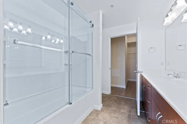 an empty room with wooden floor chandelier fan and windows