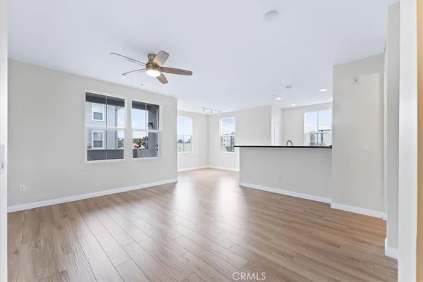 a view of a kitchen with wooden floor and a ceiling fan