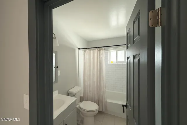 a bathroom with a granite countertop sink a toilet and shower