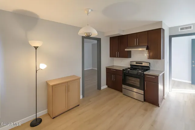 a kitchen with stainless steel appliances a stove top oven a sink and dishwasher