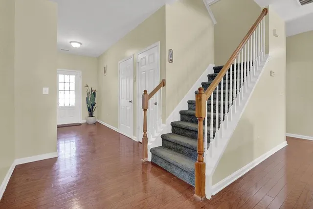 a view of a hallway with wooden floor and entryway