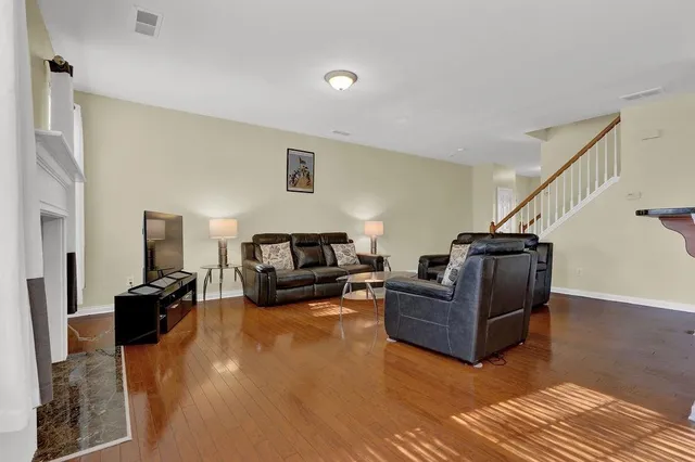 a living room with furniture and a wooden floor
