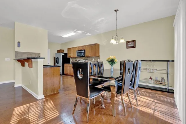 a dining room filled chandelier and wooden floor