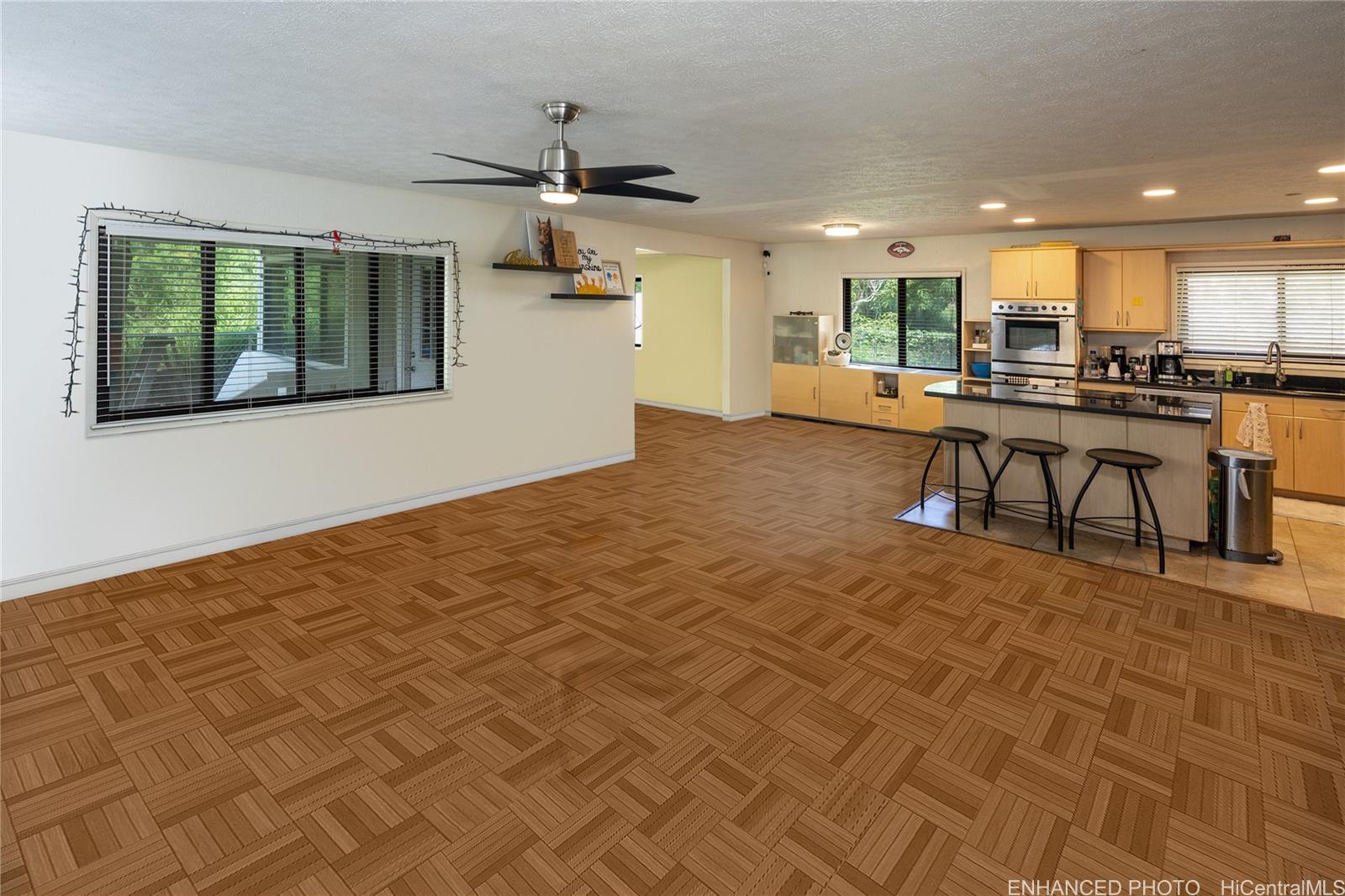 a view of a kitchen with kitchen island stainless steel appliances refrigerator sink and stove