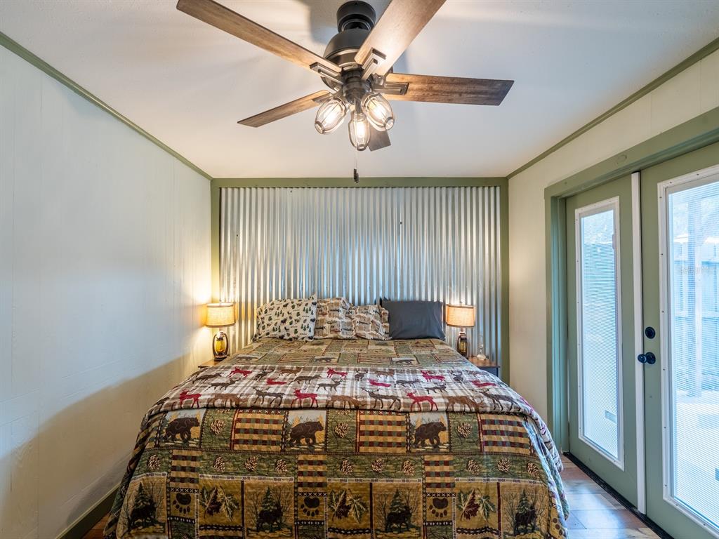 24855 Northeast 135th Street Salt Springs, FL 32134 - Photo 16 of 53 a bedroom with a bed and a chandelier
