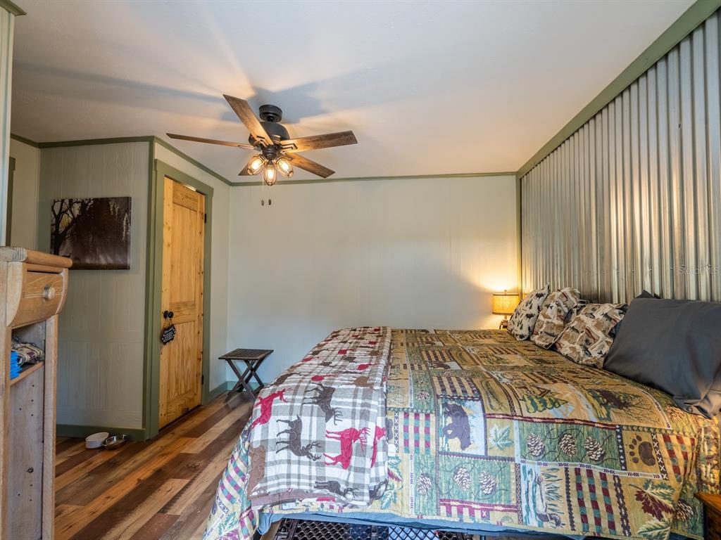 24855 Northeast 135th Street Salt Springs, FL 32134 - Photo 18 of 53 a bedroom with a bed and a chandelier