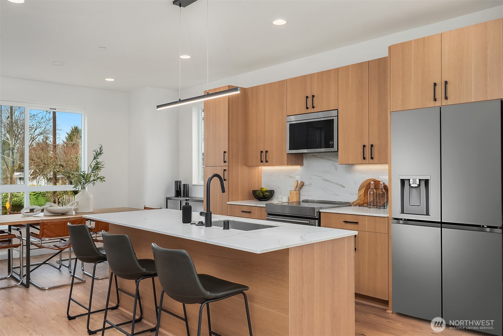 223 Northeast 75th Street Seattle, WA 98115 - Photo 3 of 33 a kitchen with stainless steel appliances a stove a sink a microwave a refrigerator and chairs