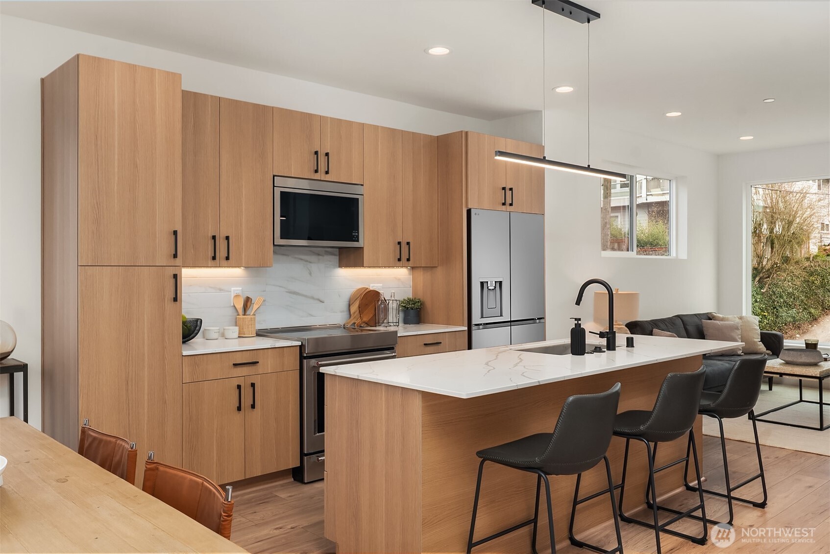 223 Northeast 75th Street Seattle, WA 98115 - Photo 4 of 33 a kitchen with stainless steel appliances kitchen island granite countertop a sink refrigerator and cabinets