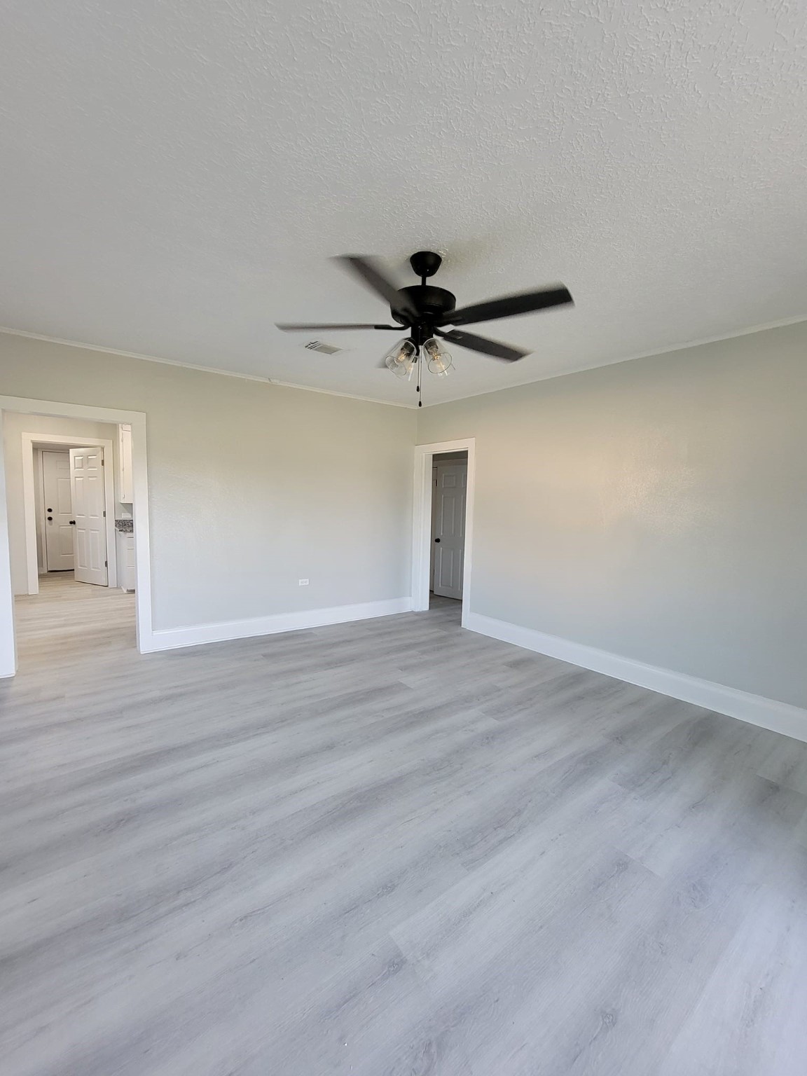 801 Willcox Street Anahuac, TX 77514 - Photo 2 of 10 a view of a livingroom with a hardwood floor and a ceiling fan
