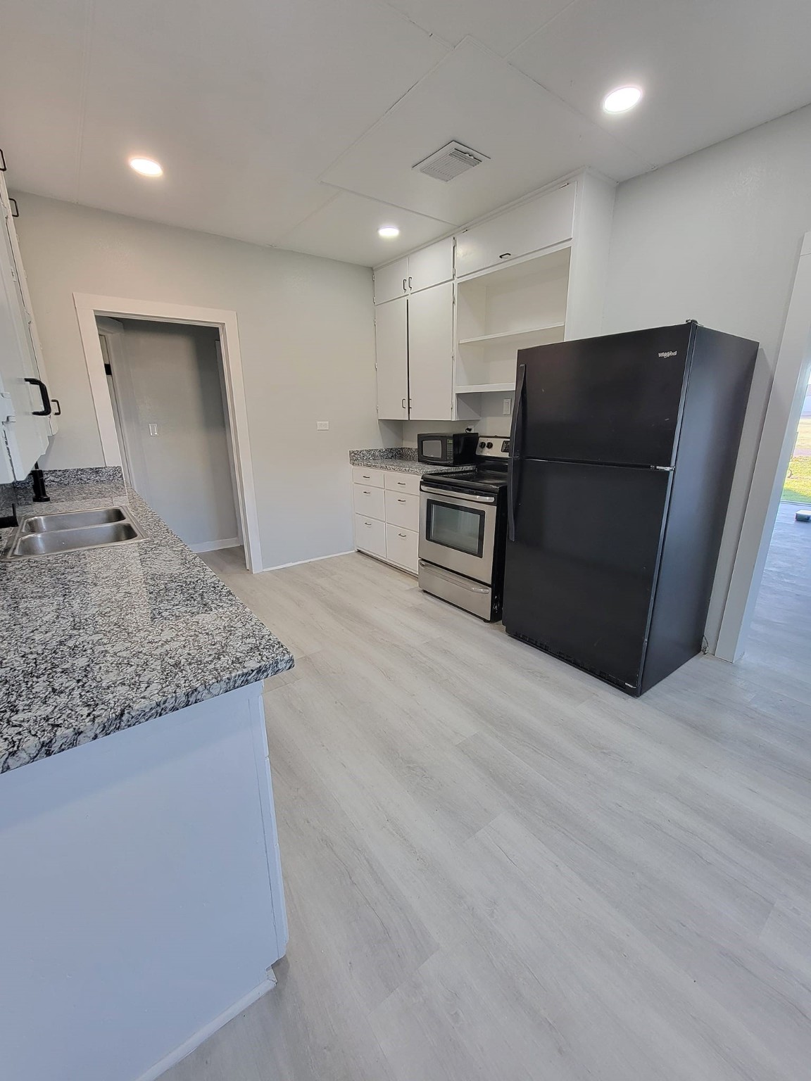 801 Willcox Street Anahuac, TX 77514 - Photo 4 of 10 a kitchen with stainless steel appliances granite countertop a refrigerator and a stove