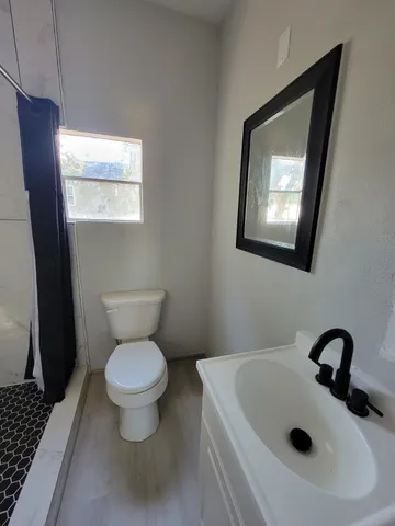 a bathroom with a toilet sink and mirror